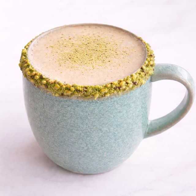 Latte Pistaccino - Espresso simple con leche vaporizada, con un sutil borde de praliné de pistacho. en Le Grenier