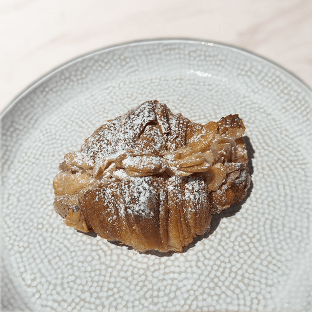 Croissant Frangipane - Croissant con crema de pasta de almendra y almendras caramelizadas encima en Le Grenier