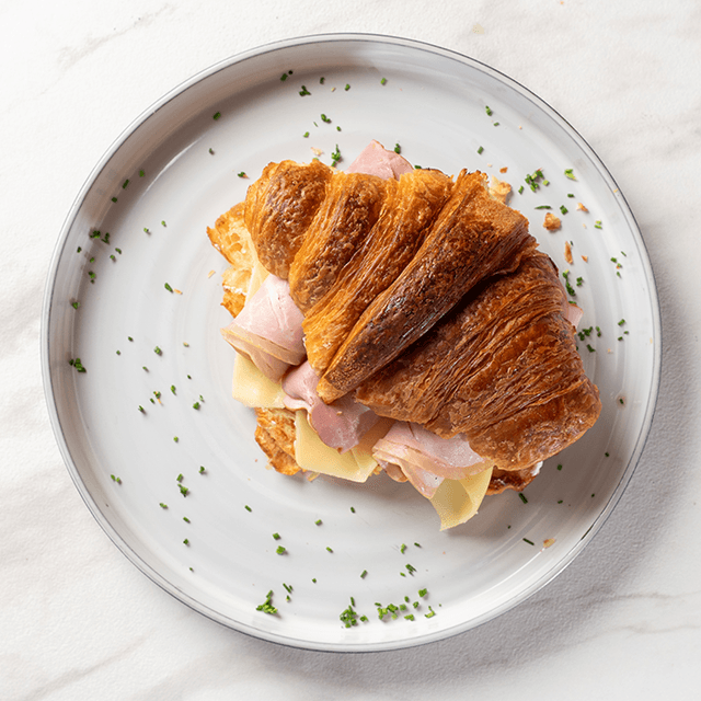Croissant Jamón & Queso - Croissant de mantequilla relleno con queso gouda derretido y jamón artesanal en Le Grenier